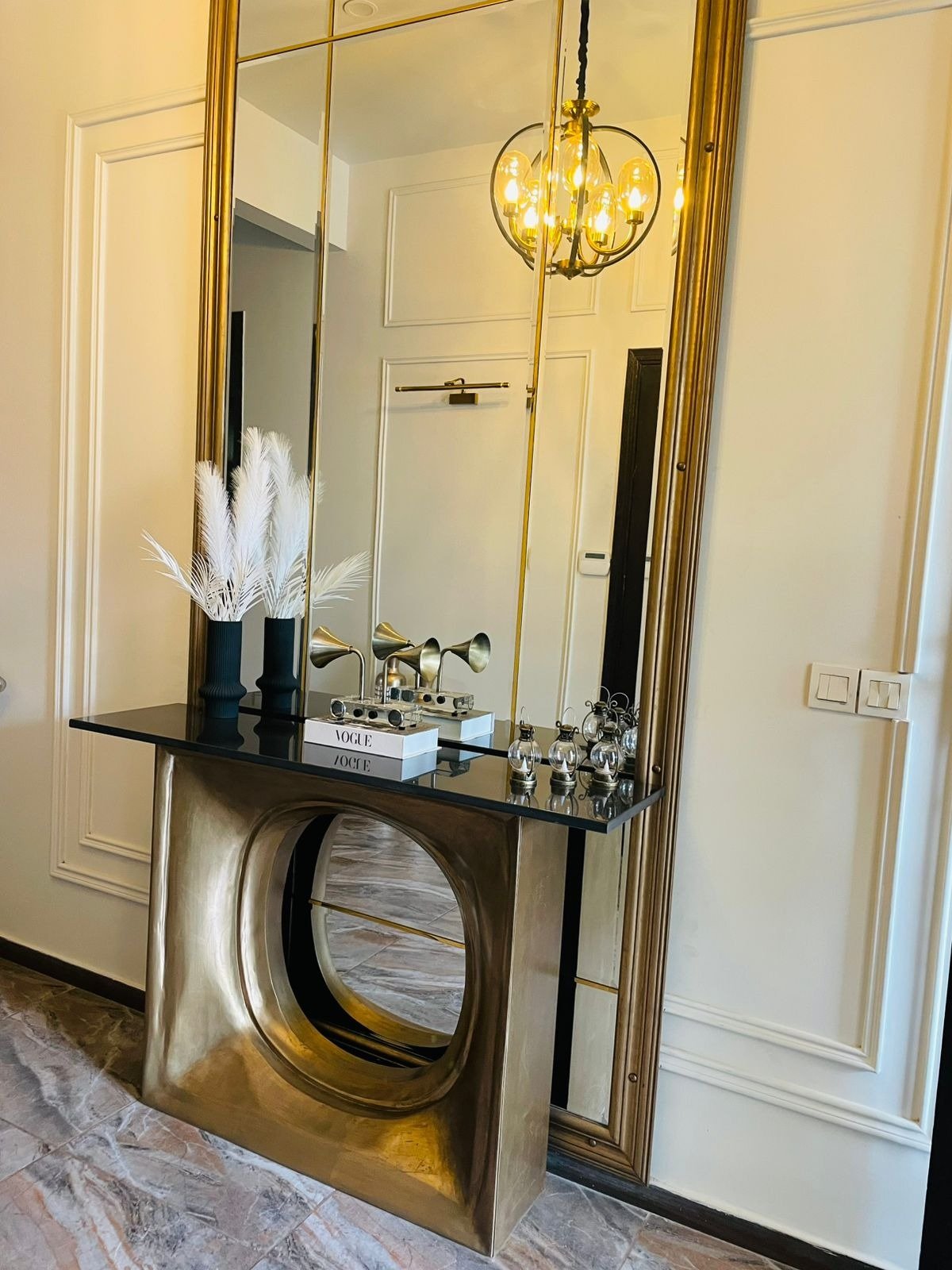 Brass console table with circular cut-out and antique mirror, DHA Karachi residence